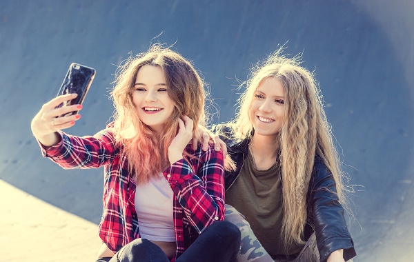 Two teenage girls taking a selfie together.