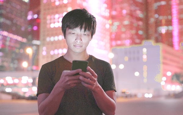 Teenage boy looking at his mobile phone.