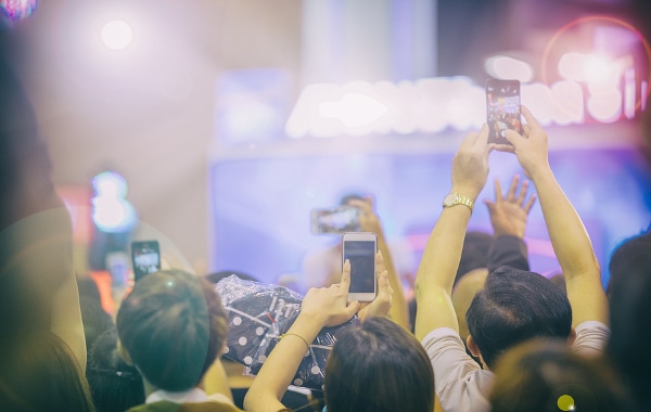 People at a concert taking photos and video with their mobile phones.