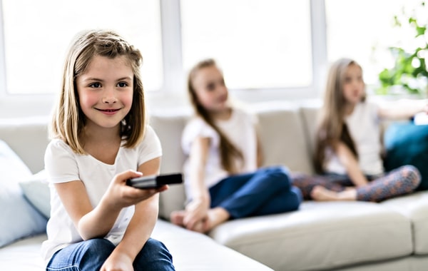 Young girl using a tv remote.