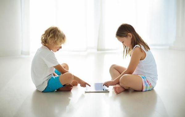 Two young teens using a tablet.