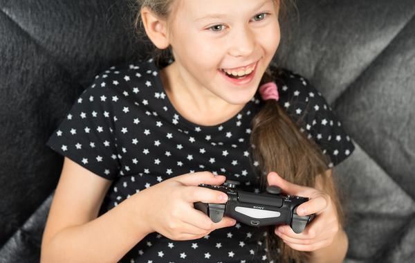 Young teen girl using a game controller.
