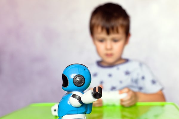 Boy controlling a mini robot with a phone app.