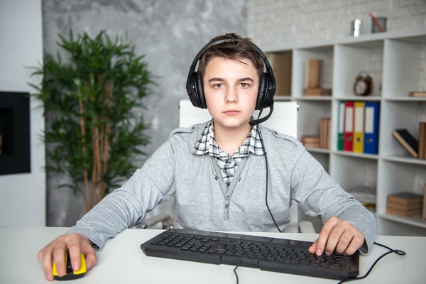 Teen sitting at a desk wearing a headset.