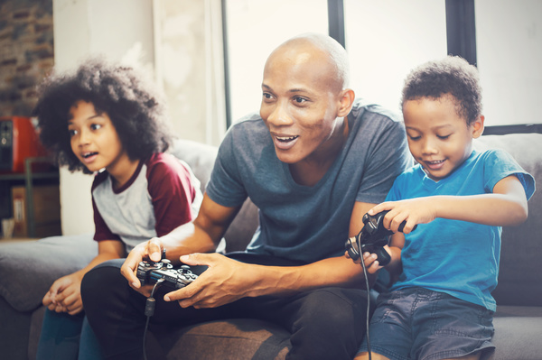 Adult playing video games with two children.