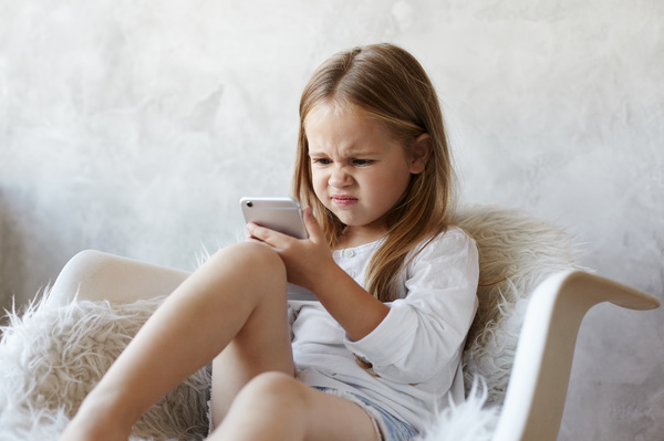 Child making a face at her phone.