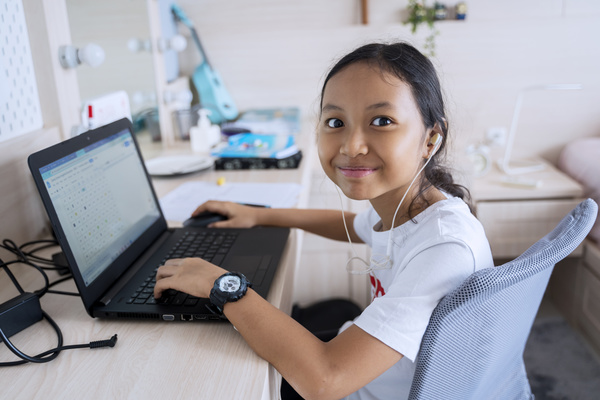 Smiling child using a laptop.