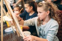 Children painting on canvases