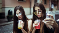 Two teens drinking from plastic cups